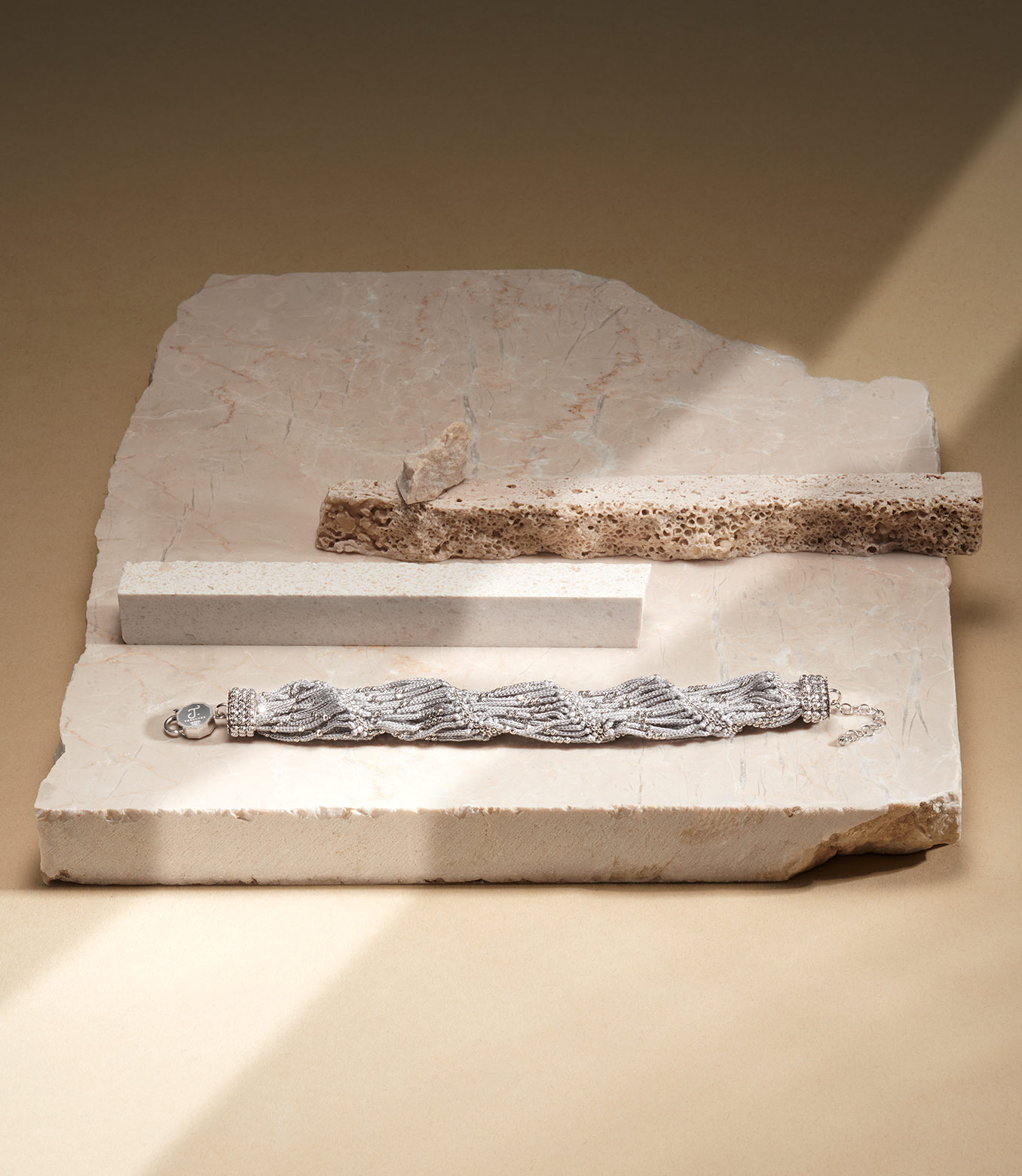 <p>Bracciale in oro bianco e seta grigia</p>